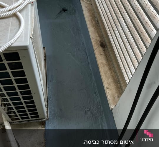אזור אטום עם חומר איטום אפור ליד חלון